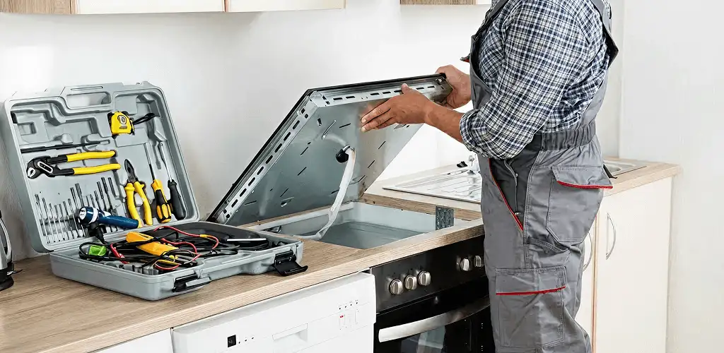 Handyman repairing a cooktop and checking wiring connections in Scottsdale, AZ