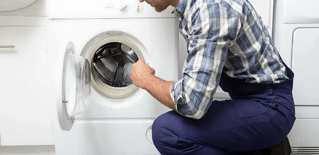 Handyman inspecting a dryer drum and internal parts for repair in Scottsdale, AZ