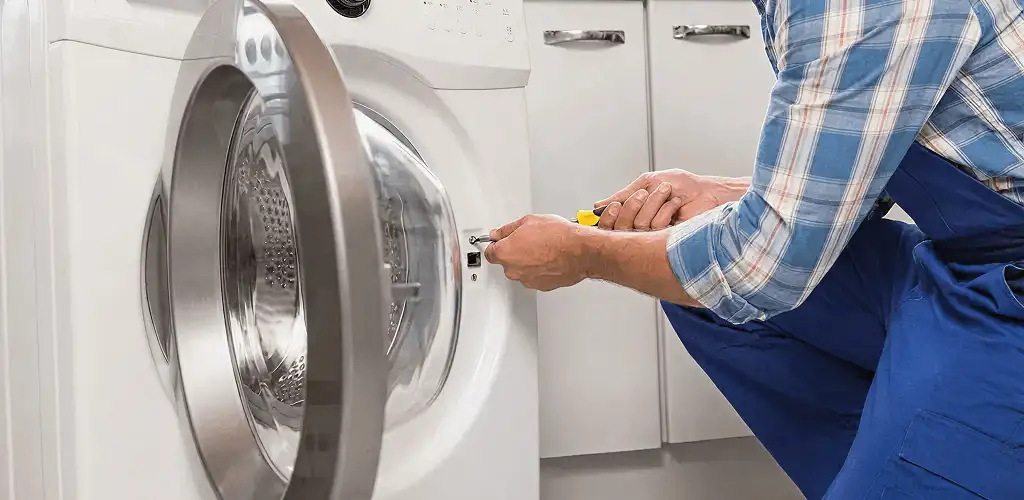 Handyman repairing a clothes dryer and checking electrical connections in Scottsdale, AZ