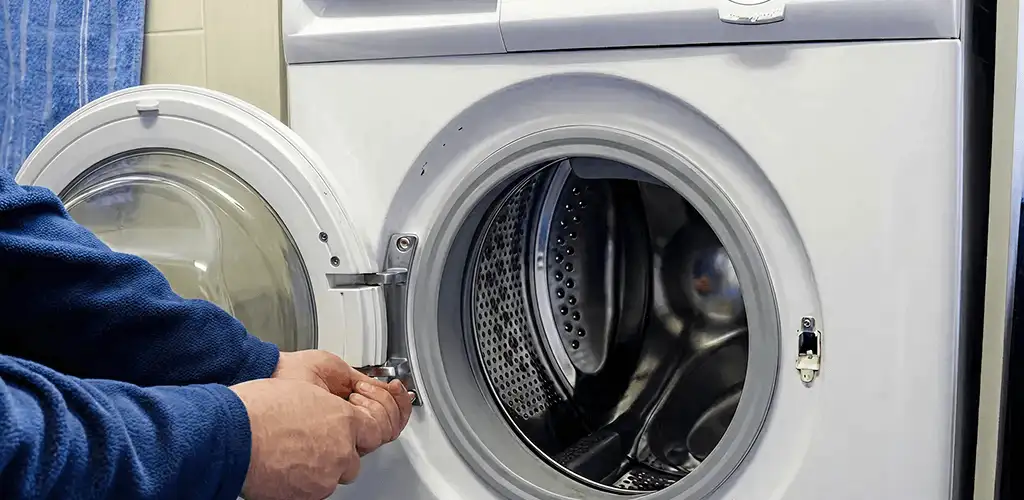 Washing machine repair handyman checking a front-load washer door and latch in Scottsdale, AZ