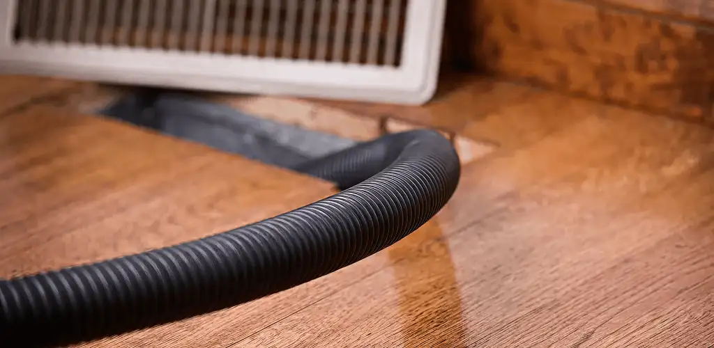 Air duct cleaning hose inserted into a floor vent for ductwork cleaning in Scottsdale, AZ