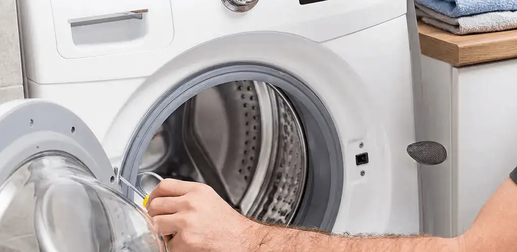 Handyman repairing a front-load washing machine and inspecting the drum in Scottsdale, AZ