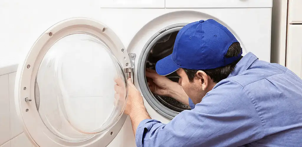 Washing machine repair handyman inspecting a front-load washer drum in Scottsdale, AZ