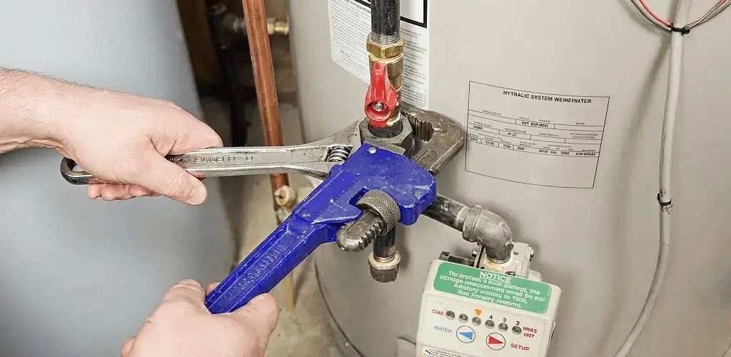Water heater repair technician tightening the shutoff valve and supply line in Scottsdale, AZ